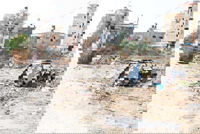 A bombed-out car in rubble – Gaza City.