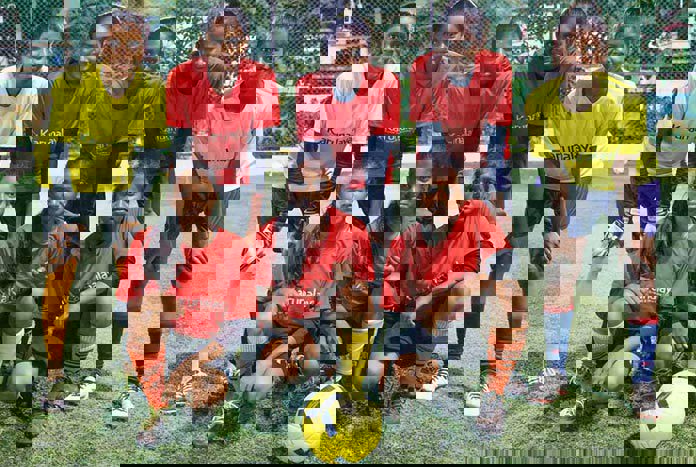 Young Indian women line up in their football kit after practice.